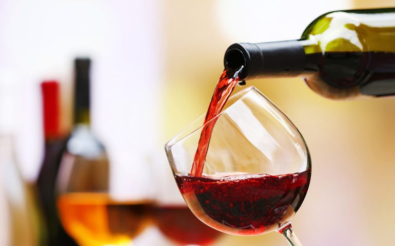 Red wine pouring into wine glass, close-up