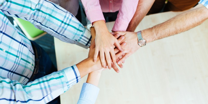 Group of corporate people working on new project joining hands