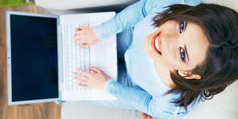 Woman with laptop looking up.