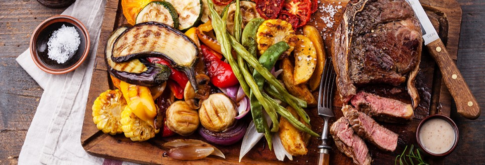 Club Beef steak with pepper sauce and Grilled vegetables on cutting board on dark wooden background