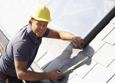 Roofer Working On Exterior Of New Home