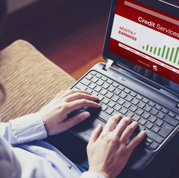 Woman checking earnings by Online Banking. Typing on the keyboar