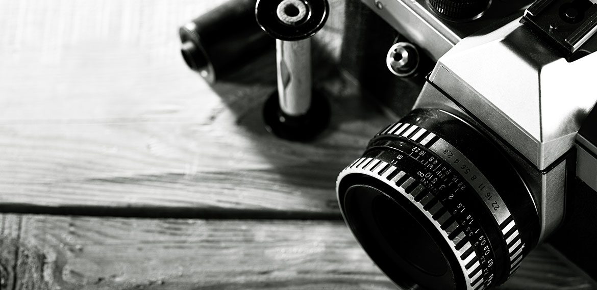 Vintage 35 mm film photo camera over wooden desk