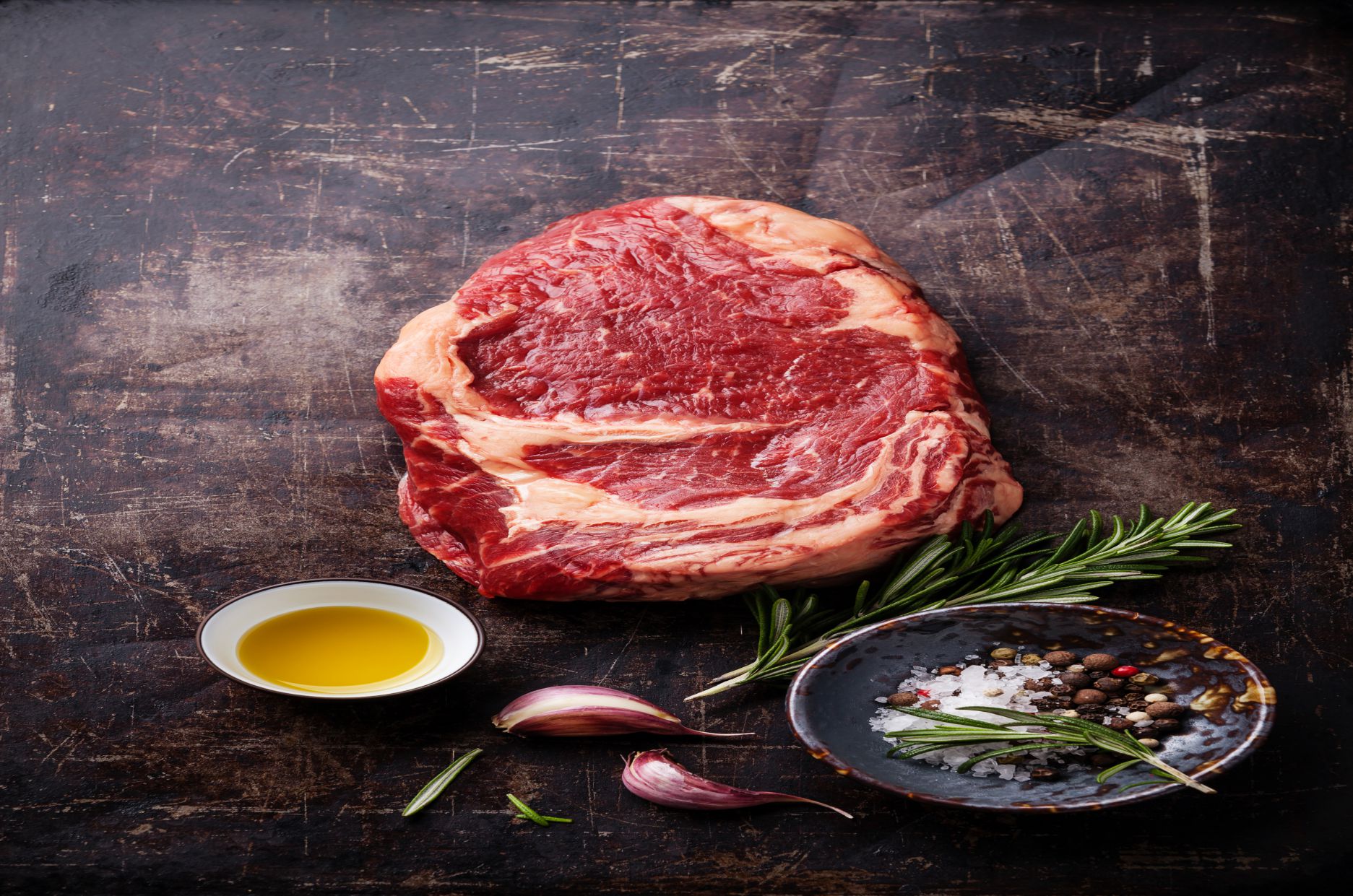 Raw fresh meat Ribeye Steak and seasonings on dark background