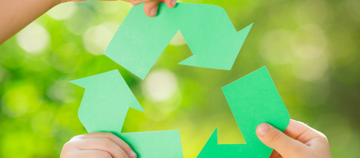 Paper RECYCLE sign in children`s hands